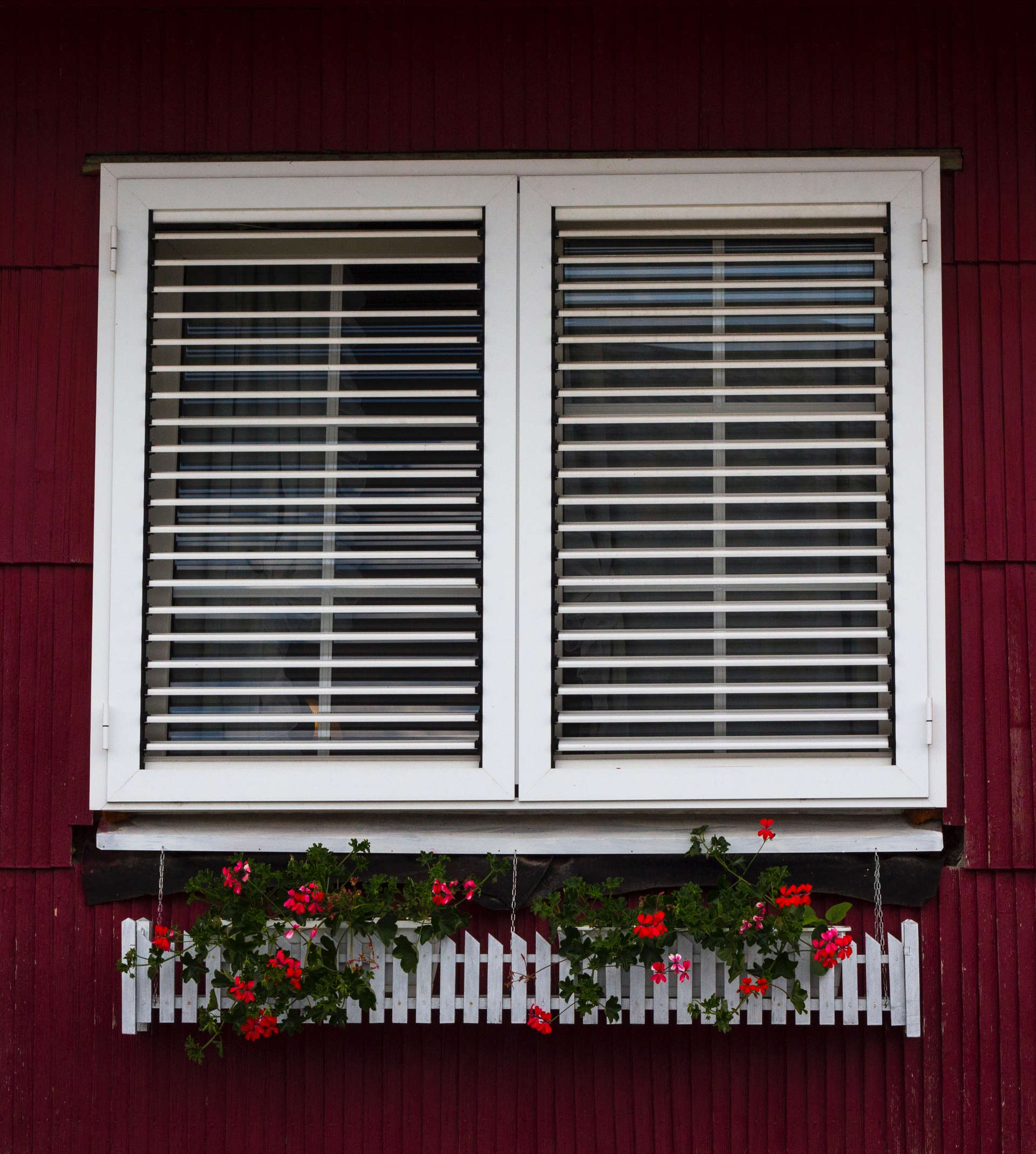a white PVC window with a flower box underneath